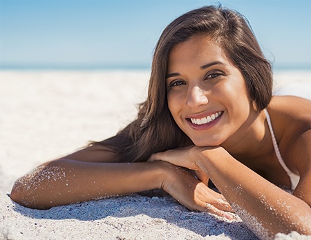 A photo of a happy young woman in swimwear enjoying facial fat grafting