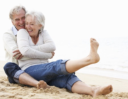 A photo of a senior Couple Sitting On Beach Together Face-Lift