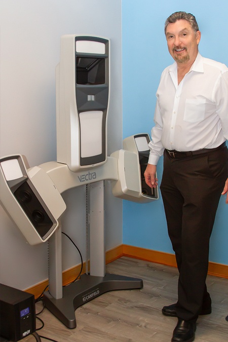 Dr. Peña standing next to Vectra 3D machine