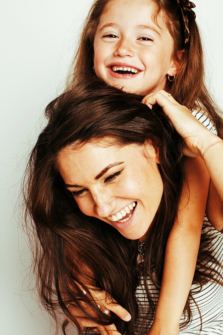 A Portrait Photo of a mother and child smiling, after a mommy make over